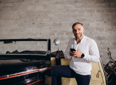 A man with a phone near a retro car. Collector of retro cars