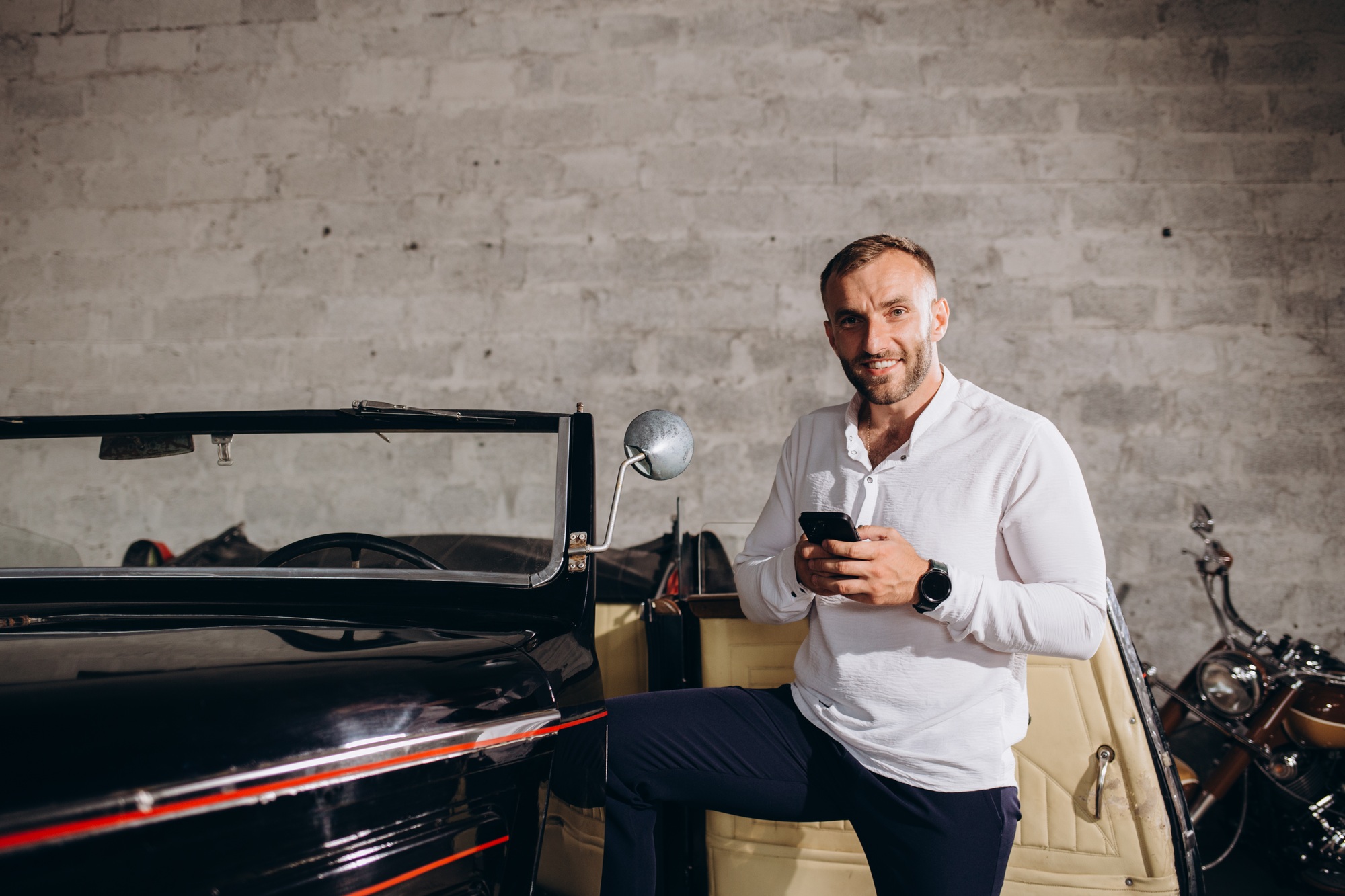 A man with a phone near a retro car. Collector of retro cars