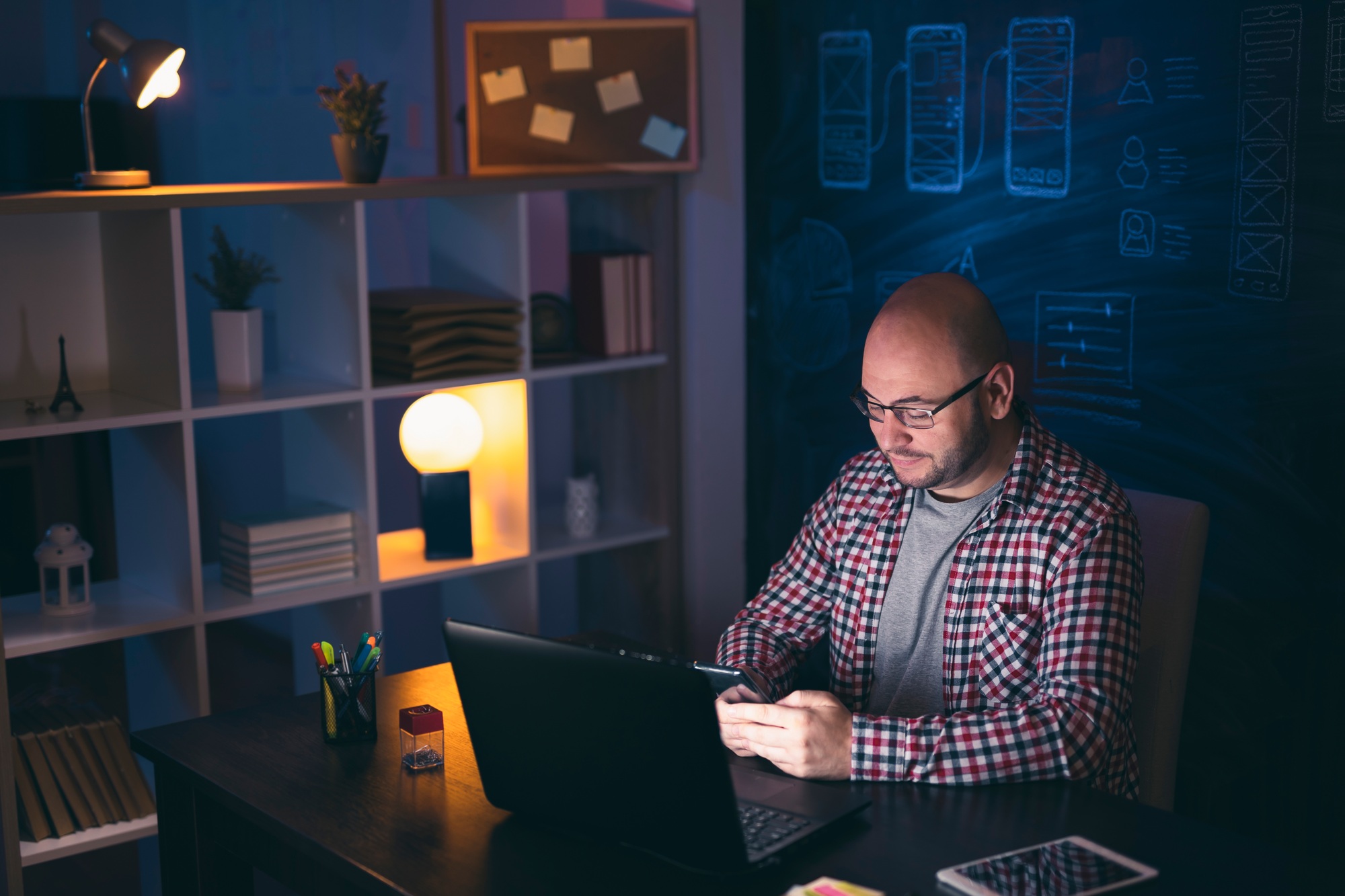 Man tying text message while working late at night