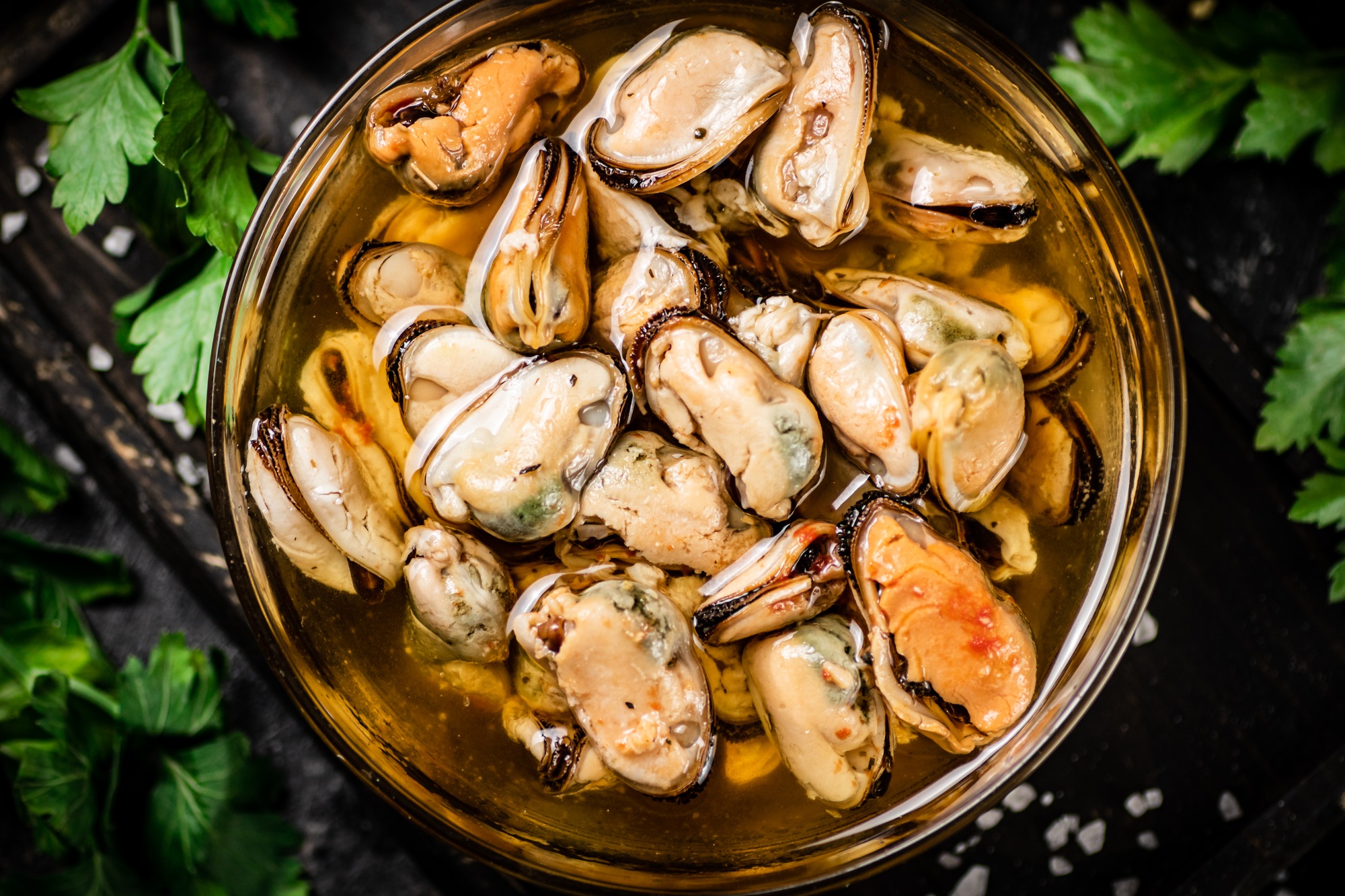 Pickled mussels in a bowl with parsley.